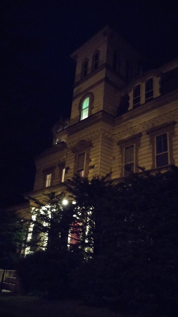 I photographed a classic haunted-looking house â€” with a mansard roof and middle tower section â€” at night.