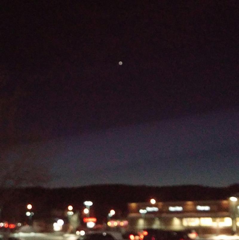 Brighter than a star, Venus hovers alone in the night sky over the horizon's last hint of day and the lights of Keene.